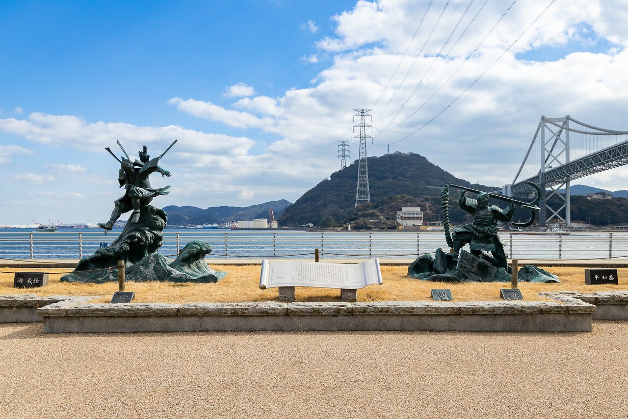Статуи Ёсицунэ и Томомори. Говорят, что течение в проливе Хаятомоносэто, который виден на заднем плане, может достигать примерно 10 узлов (18 км/ч)