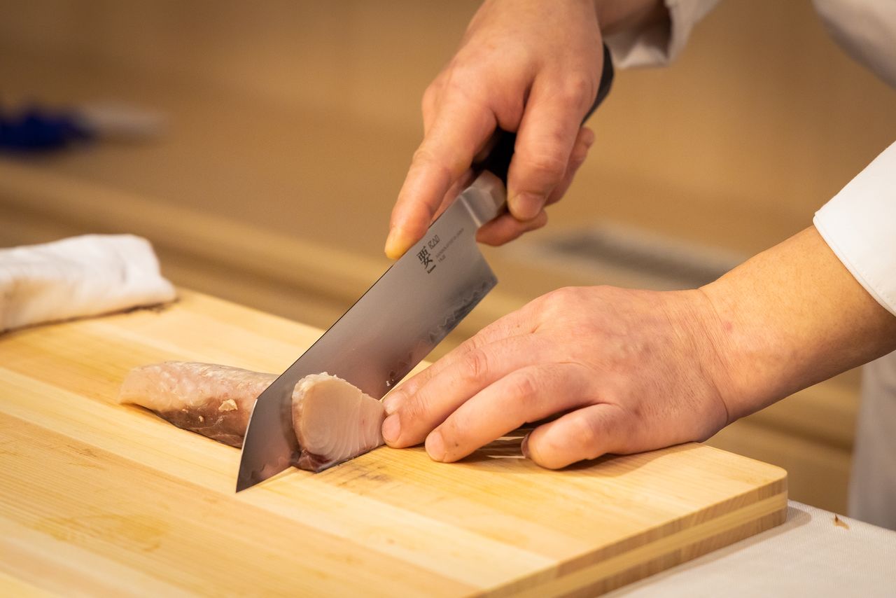 Нож легко режет слегка обжаренную рыбу савара (Scomberomorus niphonius). Красивый срез подчёркивает качество блюда