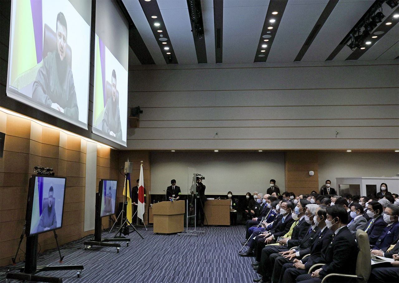 Депутаты парламента Японии слушают онлайн-выступление в парламенте президента Зеленского 23 марта 2022 года в зале Палаты представителей в Нагата-тё в Токио (Jiji Press)