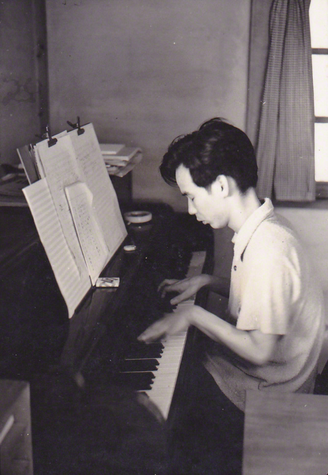 Такэмицу (на фото здесь в 1950-х годах) использовал пианино на начальном этапе работы над своими произведениями