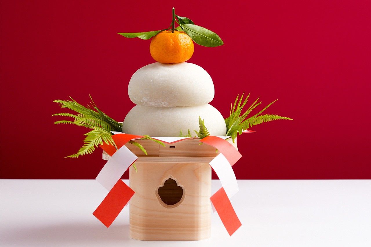 Кагами моти, украшенные апельсином дайдай, папоротником урадзиро и вотивными бумажными полосками сидэ (© Pixta)