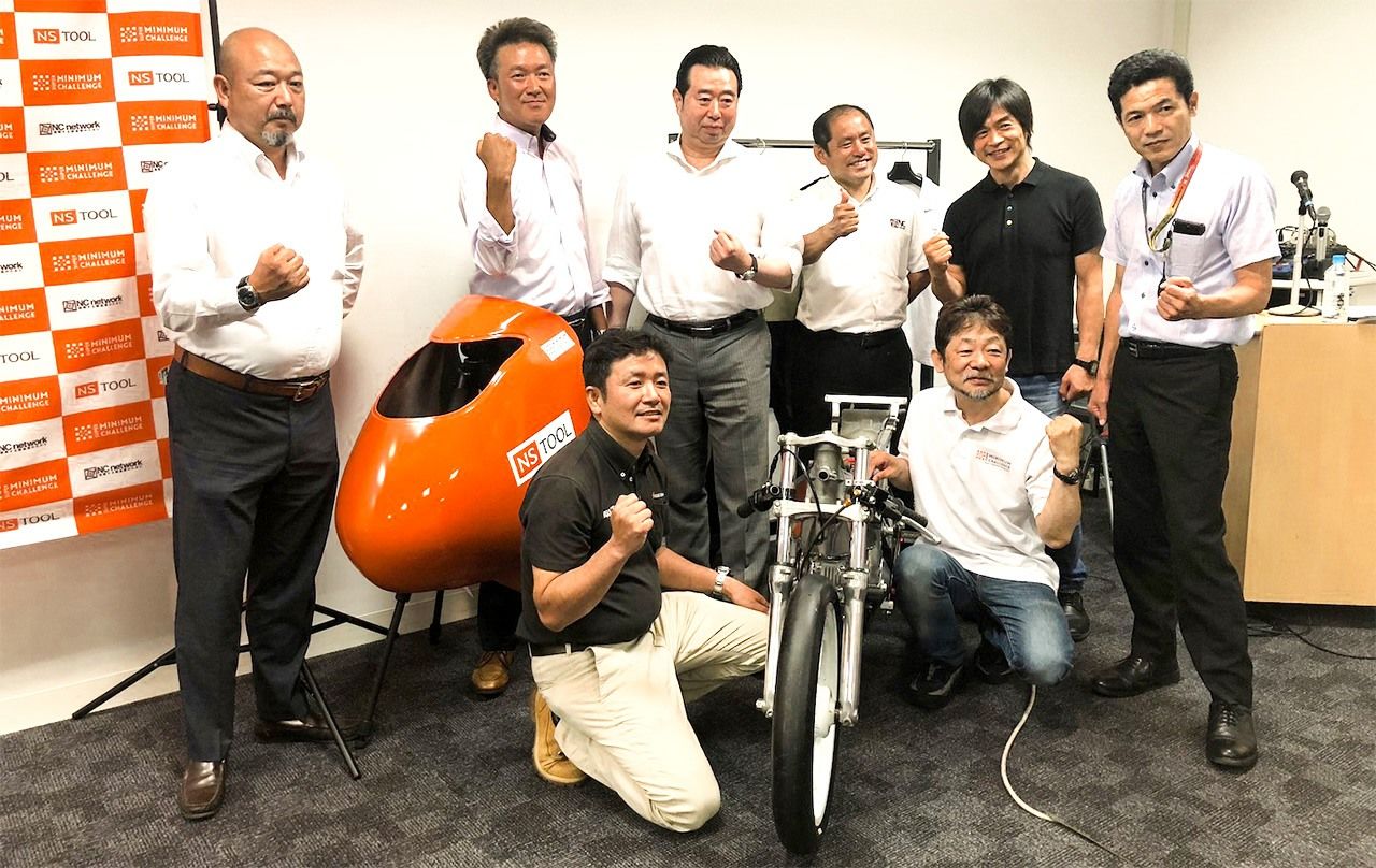 В 2017 году родилась команда под названием Super Minimum Challenge Racing Team, в которую уверенные в своих компетенциях инженеры привнесли новейшие технологии и материалы. «Если это и не ракета из района умельцев Ситамати, то как минимум мотоцикл, достойный Ситамати» (впереди справа Тикаканэ, в середине сзади президент «Ниссин когу» Гото Хиродзи)