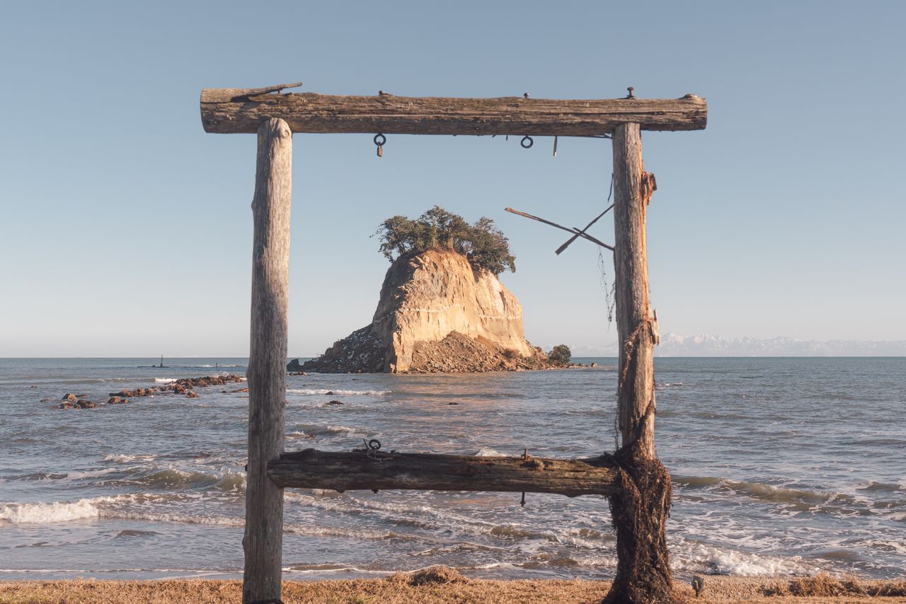 Остров Мицукэдзима в городе Судзу, пострадавший от землетрясения и цунами. Информационный щит с надписью «Также известен как Гункандзима» был смыт цунами. Несмотря на это, остров сохраняет своё величественное присутствие и остаётся символом полуострова Ното. 17 января 2024 года, район Хорю-мати Укаи, город Судзу (фото Ёсиоки Эйити)