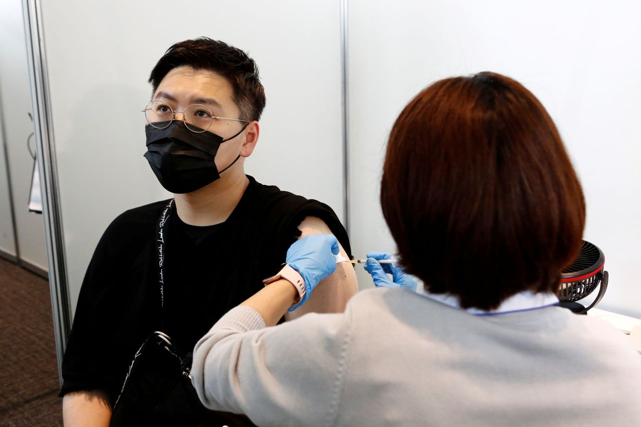 FILE PHOTO: A man receives the Moderna coronavirus vaccine at the Tokyo Metropolitan Government building in Tokyo, Japan June 25, 2021. Rodrigo Reyes Marin/Pool via REUTERS/File Photo