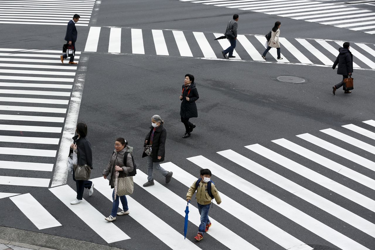 People cross a street in the Ginza shopping district in Tokyo, Japan, March 24, 2016. Japan