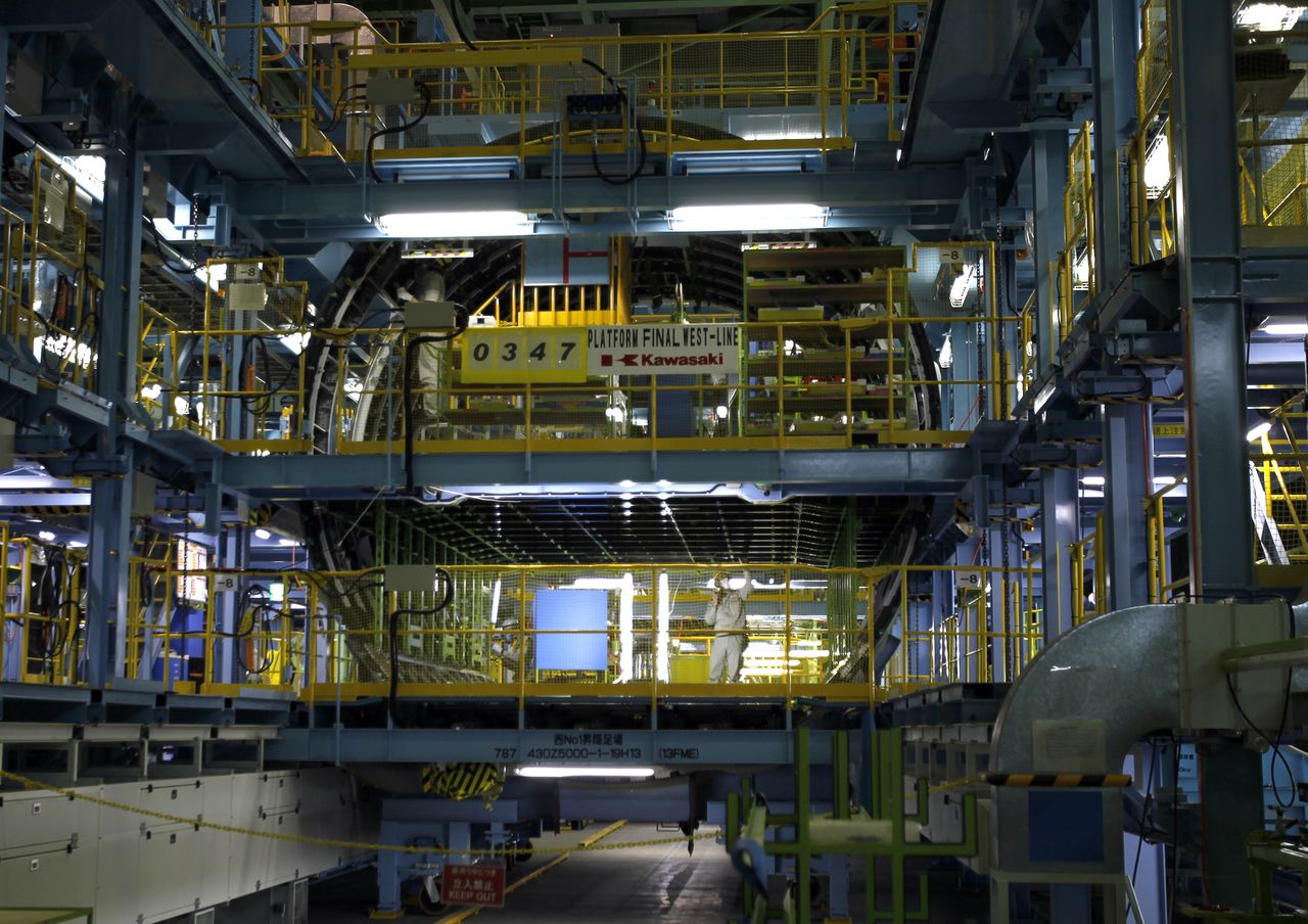 ФОТОГРАФИЯ: Рабочий на недавно построенном производственном предприятии Kawasaki Heavy Industries в Ятоми, центральная Япония, 13 марта 2015 года. REUTERS / Тим Келли
