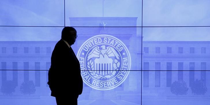 FILE PHOTO: A security guard walks in front of an image of the Federal Reserve in Washington, DC, U.S., March 16, 2016. REUTERS/Kevin Lamarque/File Photo