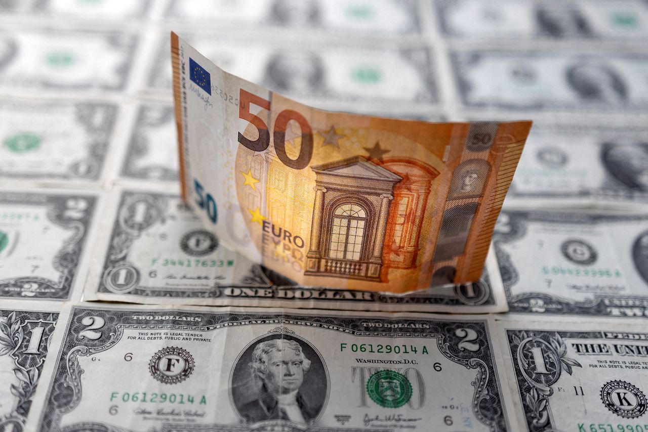 FILE PHOTO: A Euro banknote is displayed on U.S. Dollar banknotes in this illustration taken, February 14, 2022. REUTERS/Dado Ruvic/Illustration/File Photo