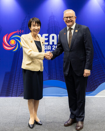 高市早苗首相(左)と握手するオーストラリアのアルバニージー首相=26日、クアラルンプール(豪首相府提供・時事)