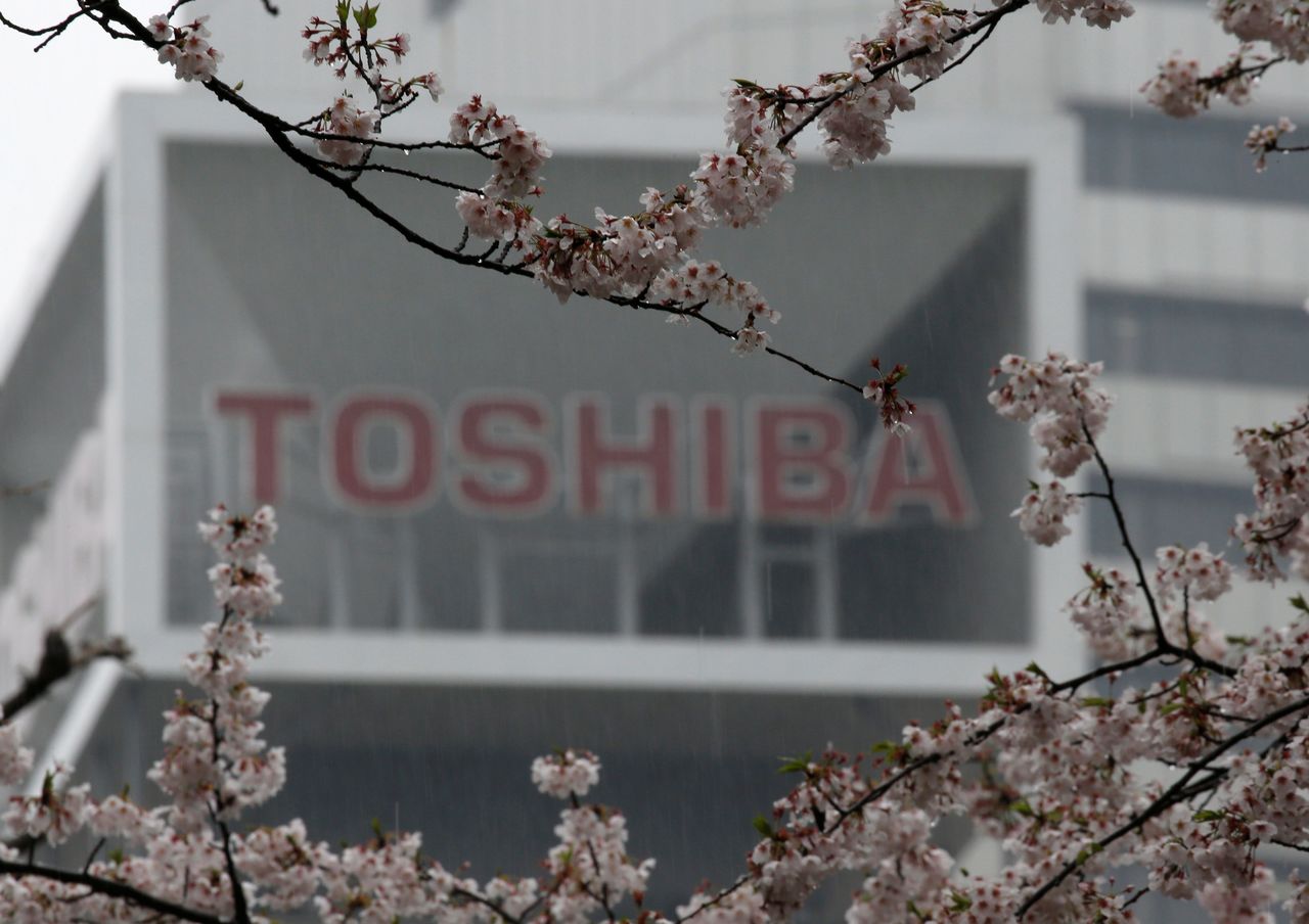 The logo of Toshiba Corp is seen behind cherry blossoms at the company