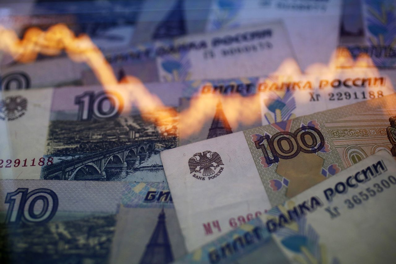 A reflection of a yearly chart of U.S. dollars and Russian roubles are seen on rouble notes in this photo illustration taken in Warsaw November 7, 2014. The rouble recovered on Friday, paring heavy losses as investors anticipated possible action by the central bank to halt a slide that could destabilise Russia