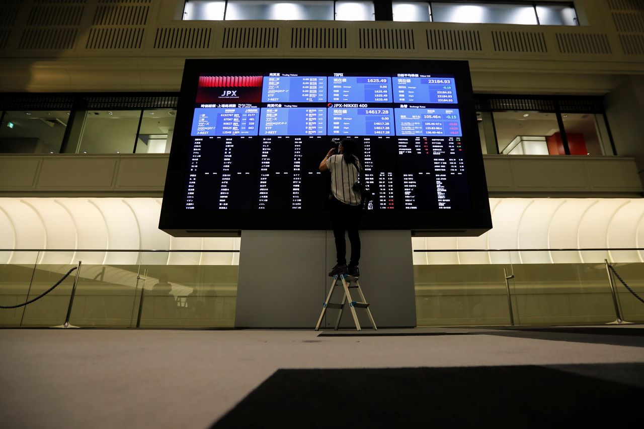 A photographer takes a picture of the blank prices in a stock quotation board at the empty Tokyo Stock Exchange (TSE) after the TSE temporarily suspended all trading due to system problems in Tokyo, Japan October 1, 2020. REUTERS/Issei Kato