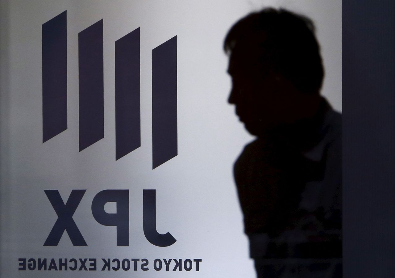 A man walks past a logo of Japan Exchange Group Inc. before a ceremony marking the end of trading in 2015 at the Tokyo Stock Exchange (TSE) in Tokyo, December 30, 2015. REUTERS/Yuya Shino