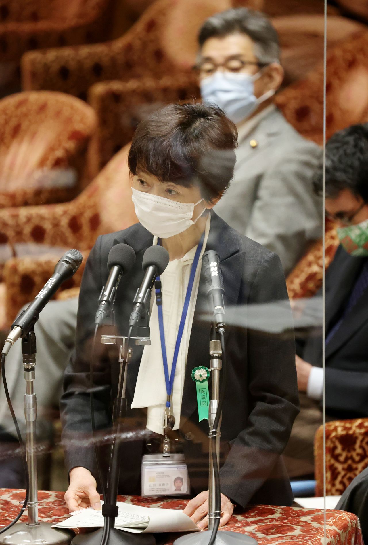  2月25日 菅義偉首相の長男正剛氏が勤める放送事業会社、東北新社から高額の会食接待を受けた山田真貴子内閣広報官は参考人として出席した衆院予算委員会で、首相が昨年出演した番組に関して、NHK関係者に抗議の電話はしていないと語った。写真は衆院予算委員会で答弁する山田内閣広報官。2月25日、国会内で撮影(2021年 時事通信)